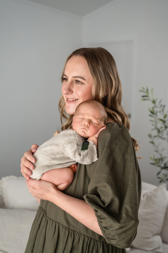 a mother with baby sleeping on her shoulder