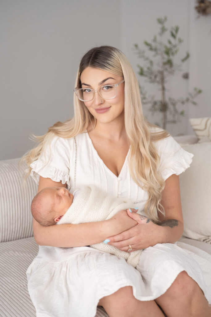 mother holding her baby looking at the camera smiling