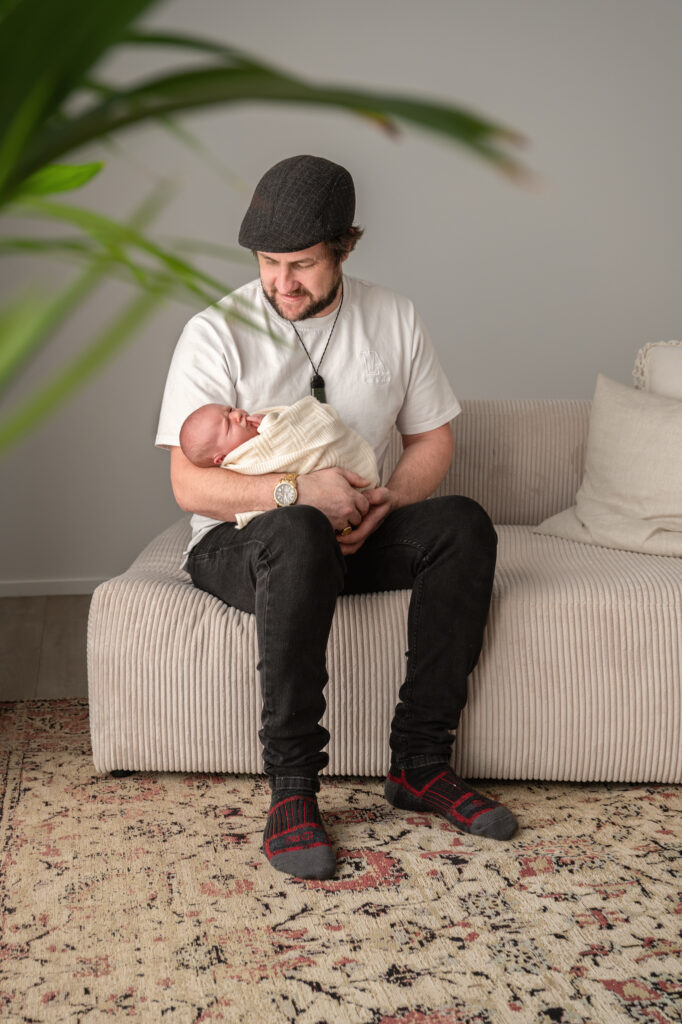 proud dad holding his baby girl in studio