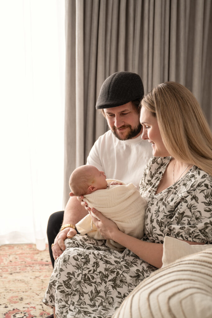 a mum and dad looking down at their baby