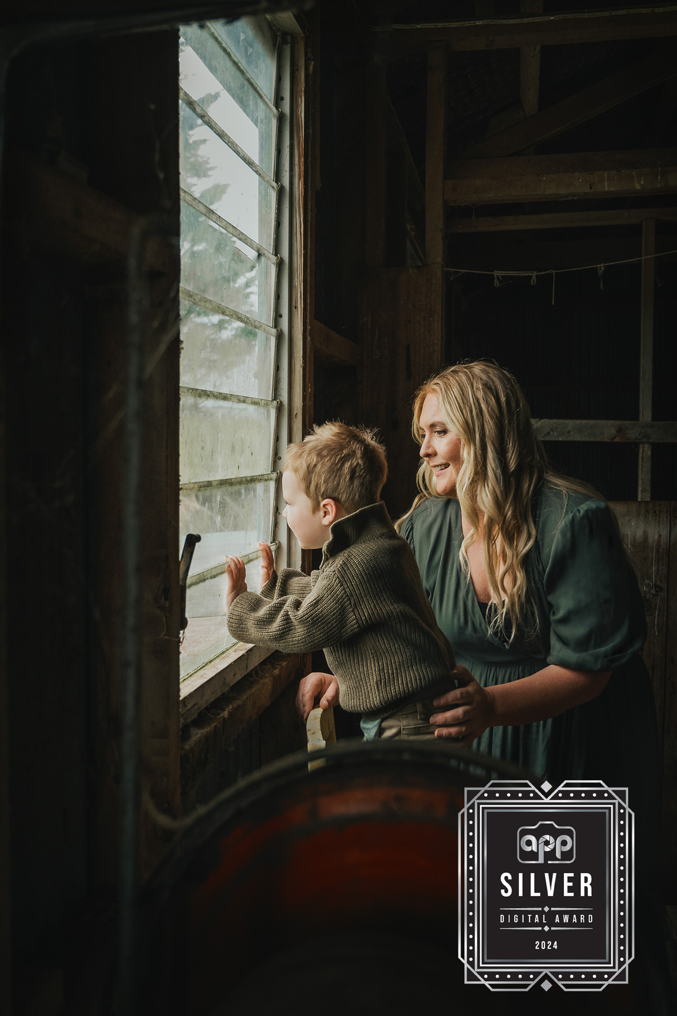 boy looking out the window of a woolshed with his mum.
I photographed James as a newborn baby