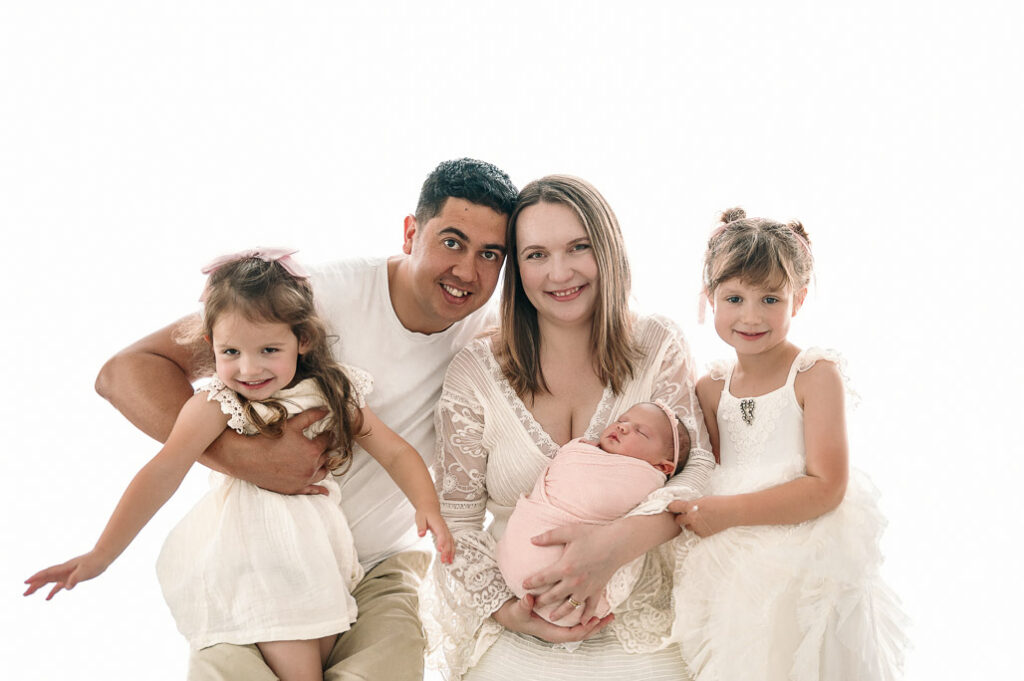 Family studio photo shoot on white wall